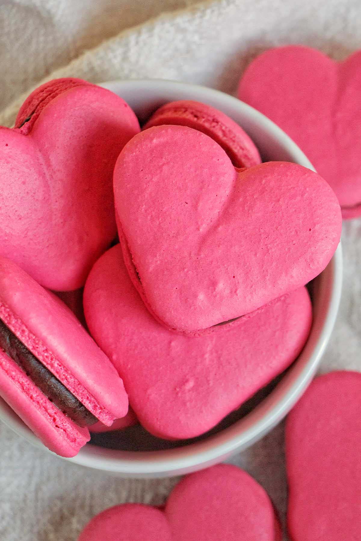 pink heart macarons filled with chocolate ganache.