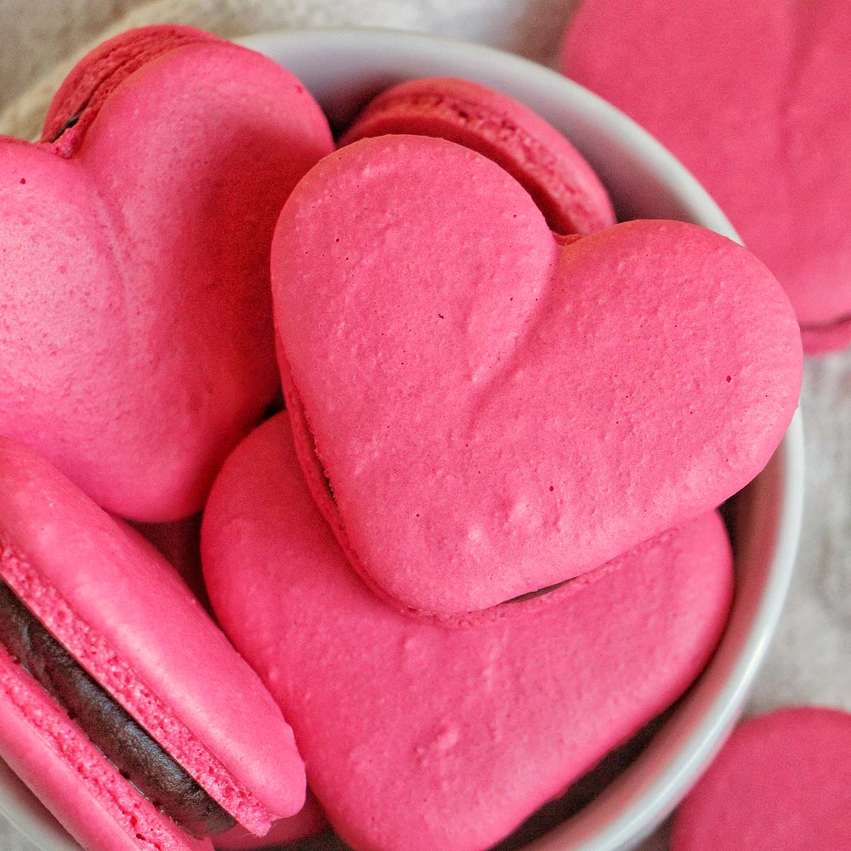 pink heart macarons filled with chocolate ganache.