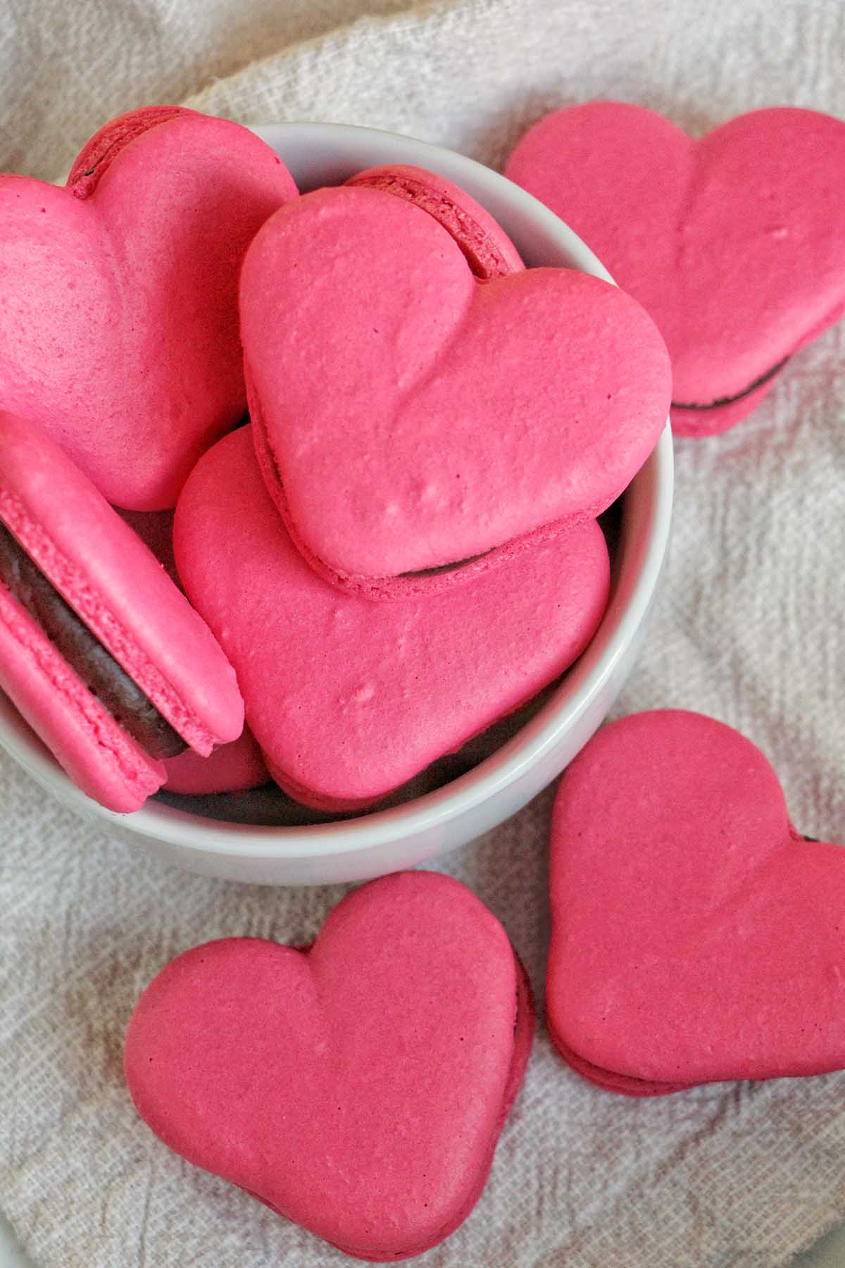 pink heart macarons filled with chocolate ganache.