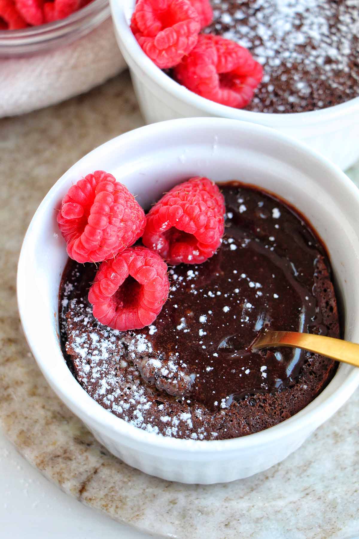 molted lava cake in a ramekin with raspberries.