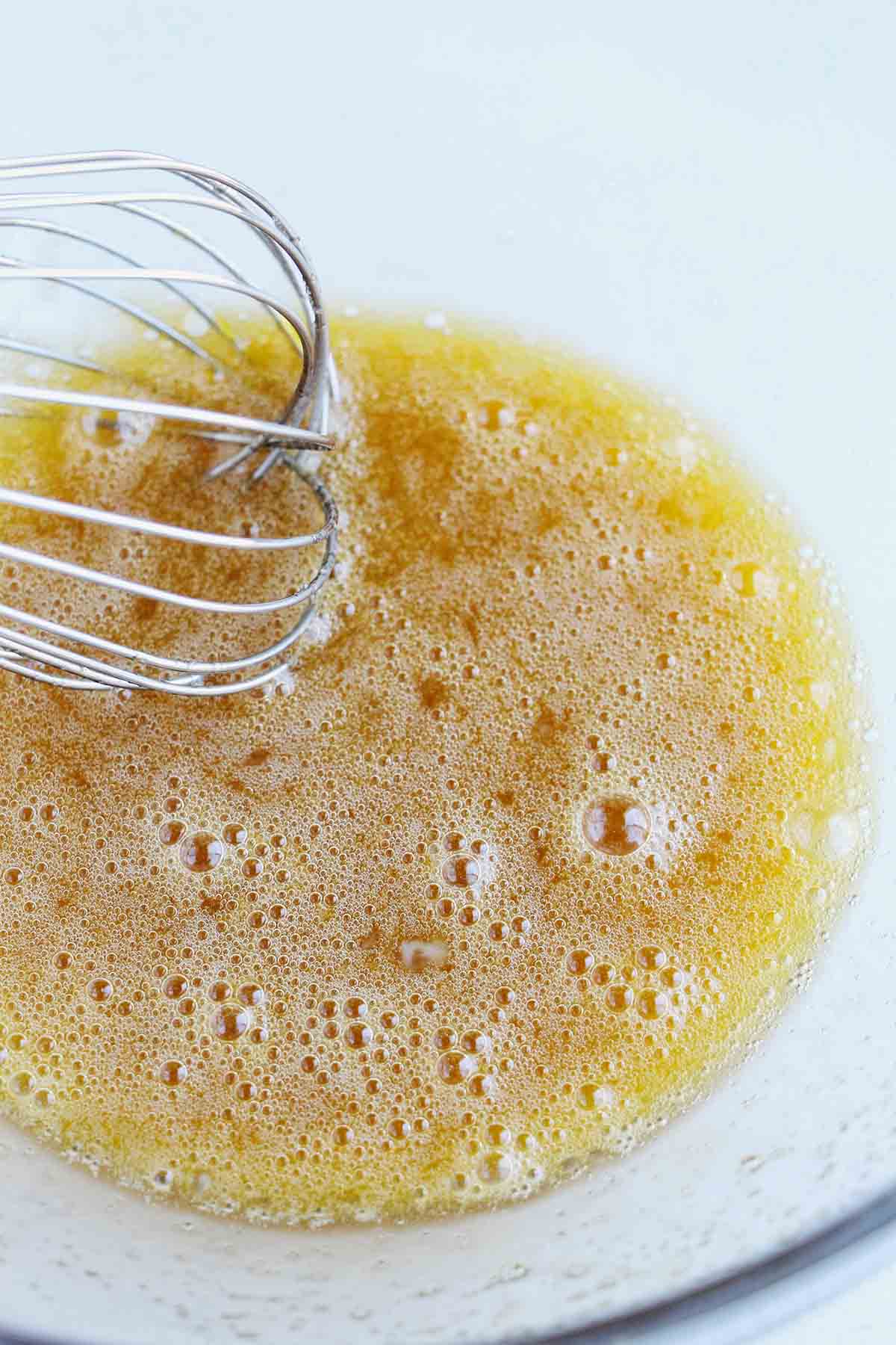 whisking eggs and sugar in a mixing bowl.
