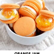 orange jam macarons in a bowl with text overlay.