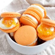 orange jam macarons in a bowl.