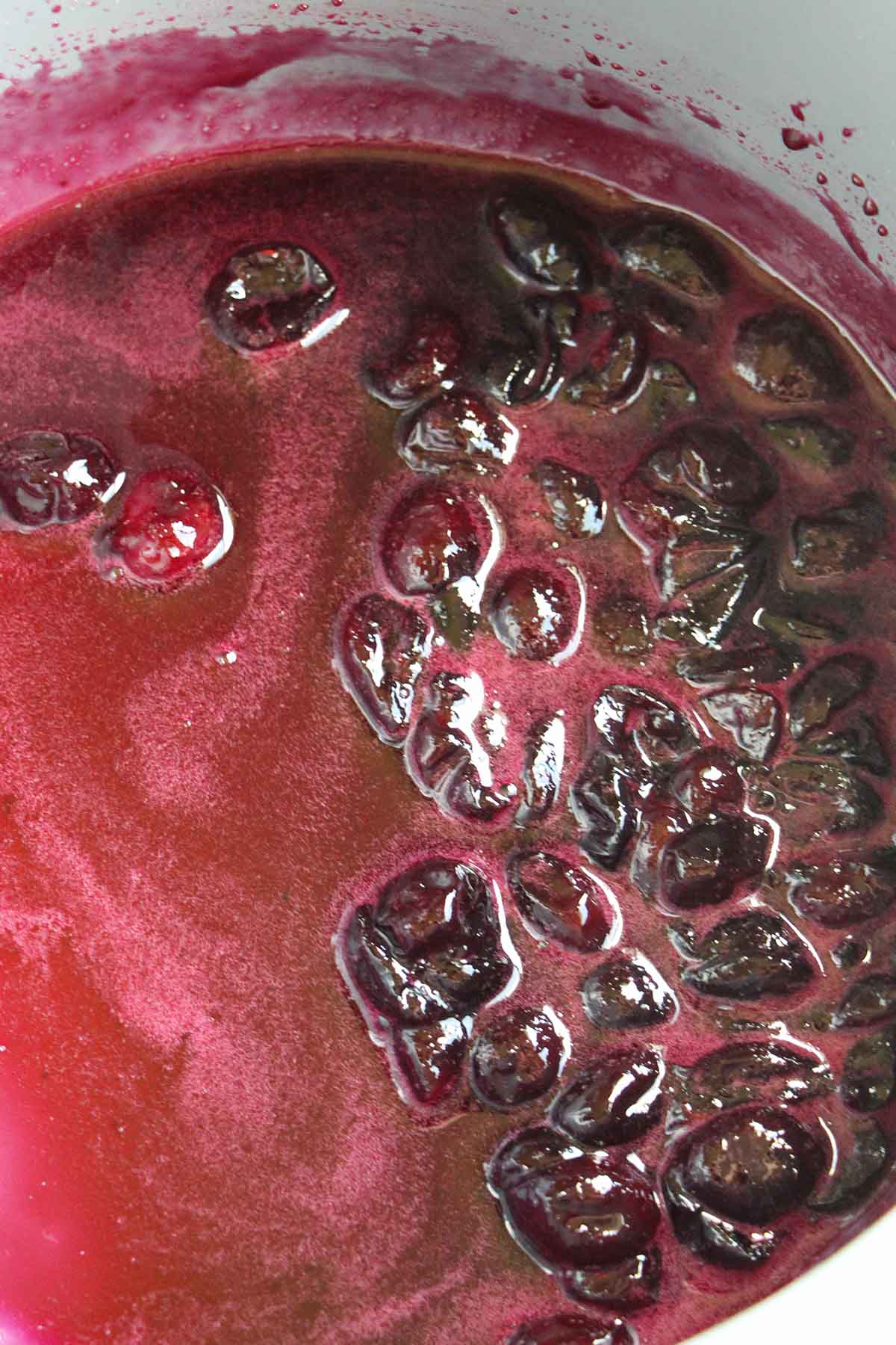 cherry jam cooking in pot.