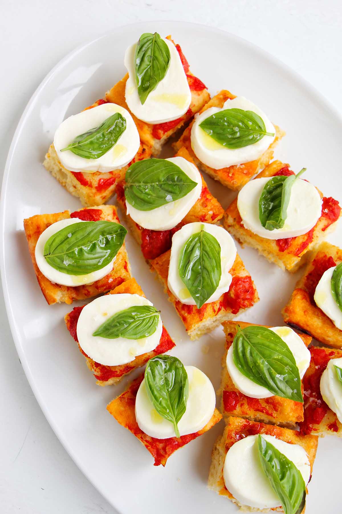tomato focaccia topped with mozzarella cheese and basil.