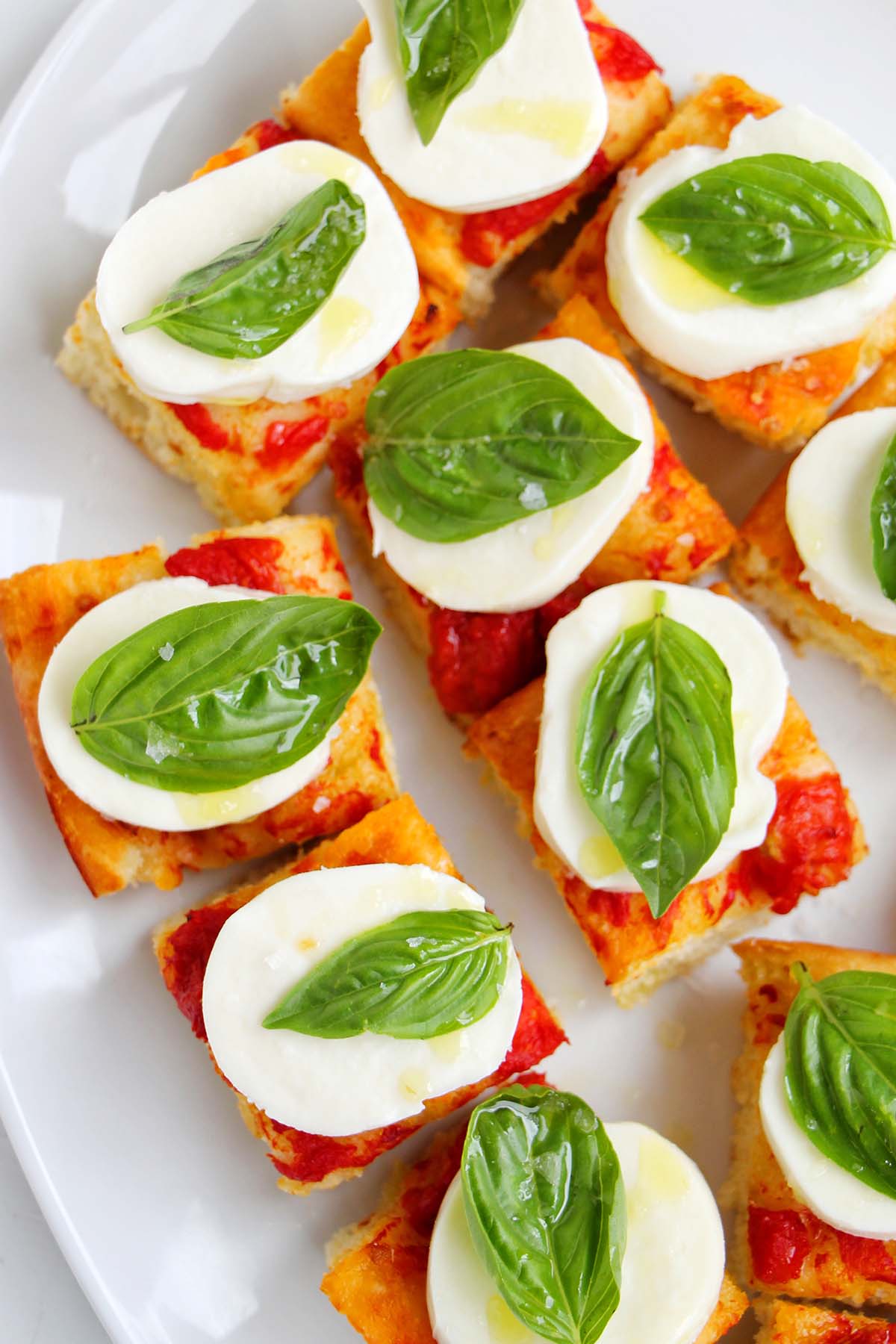 tomato focaccia topped with mozzarella cheese and basil.