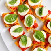 tomato focaccia topped with mozzarella cheese and basil.