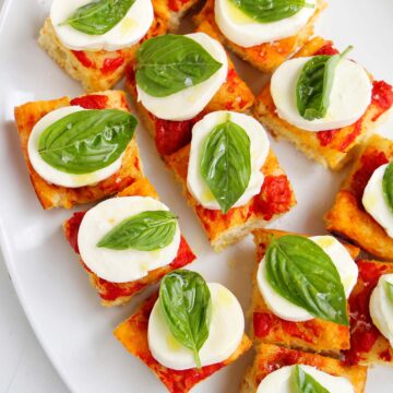 tomato focaccia topped with mozzarella cheese and basil.