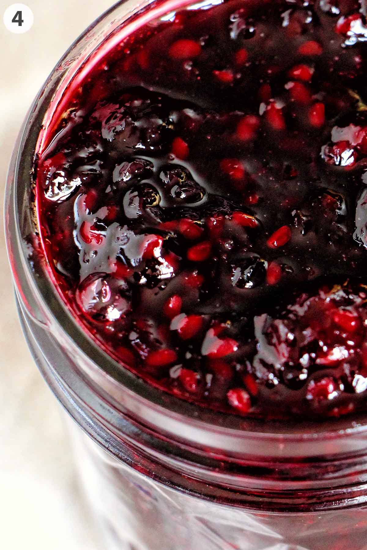 numbered photo showing blackberry jam cooling in a mason jar.