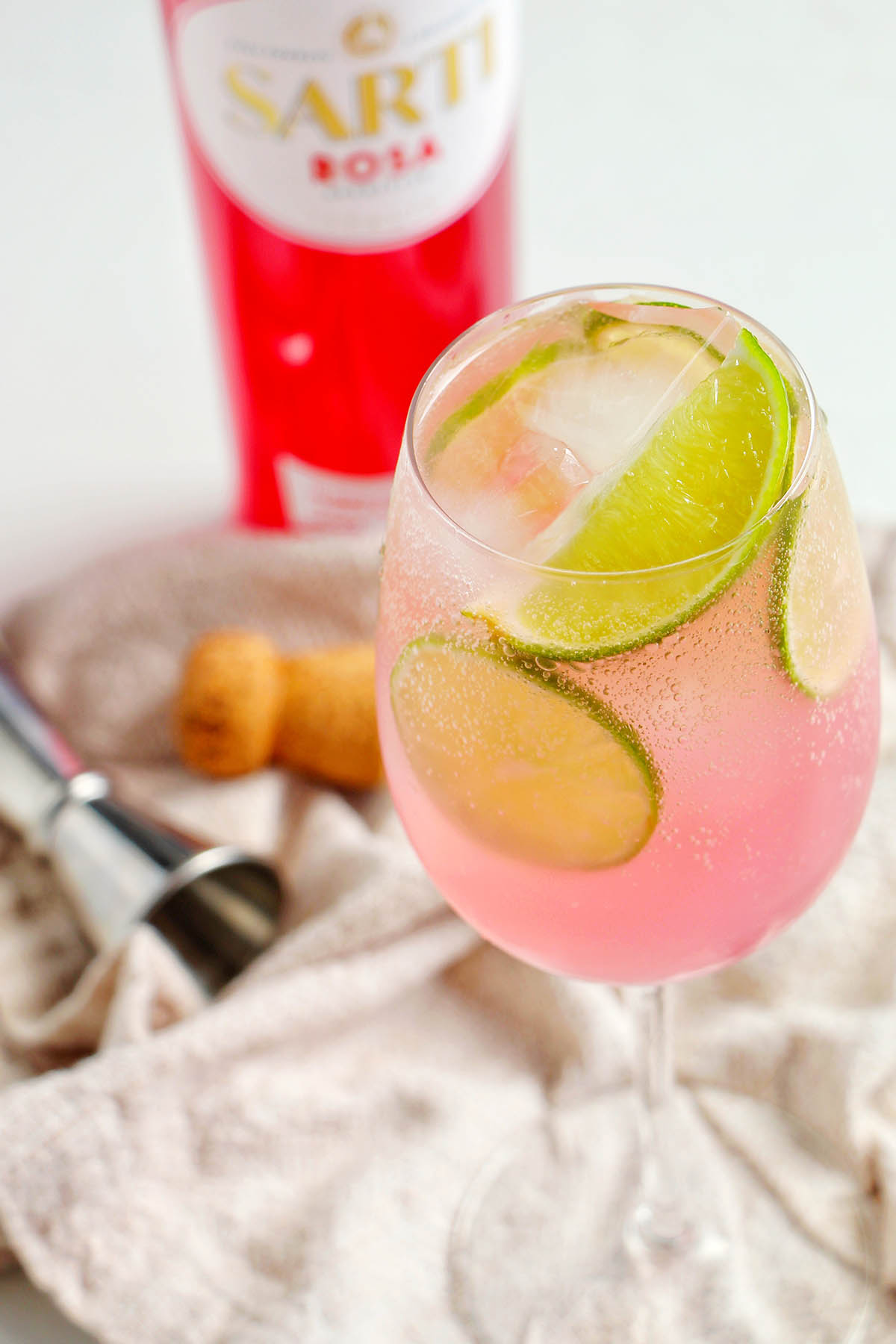 pink Sarti spritz in front of Sarti Rosa bottle.