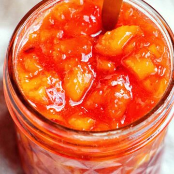 peach jam in a mason jar.
