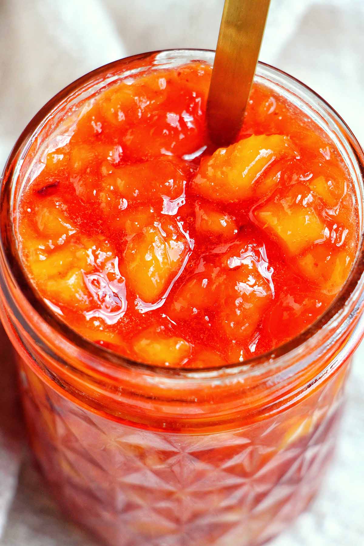 peach jam in a mason jar.